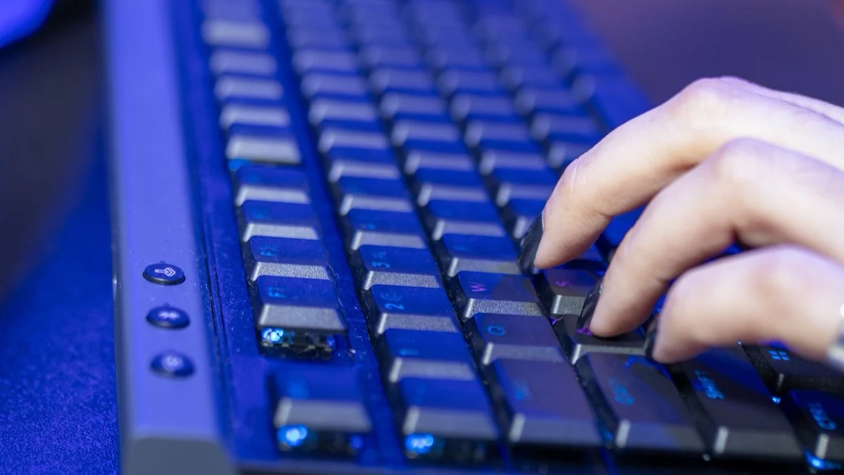 Hands typing on a keyboard in blue light, the device that now receives more Windows security fixes than ever